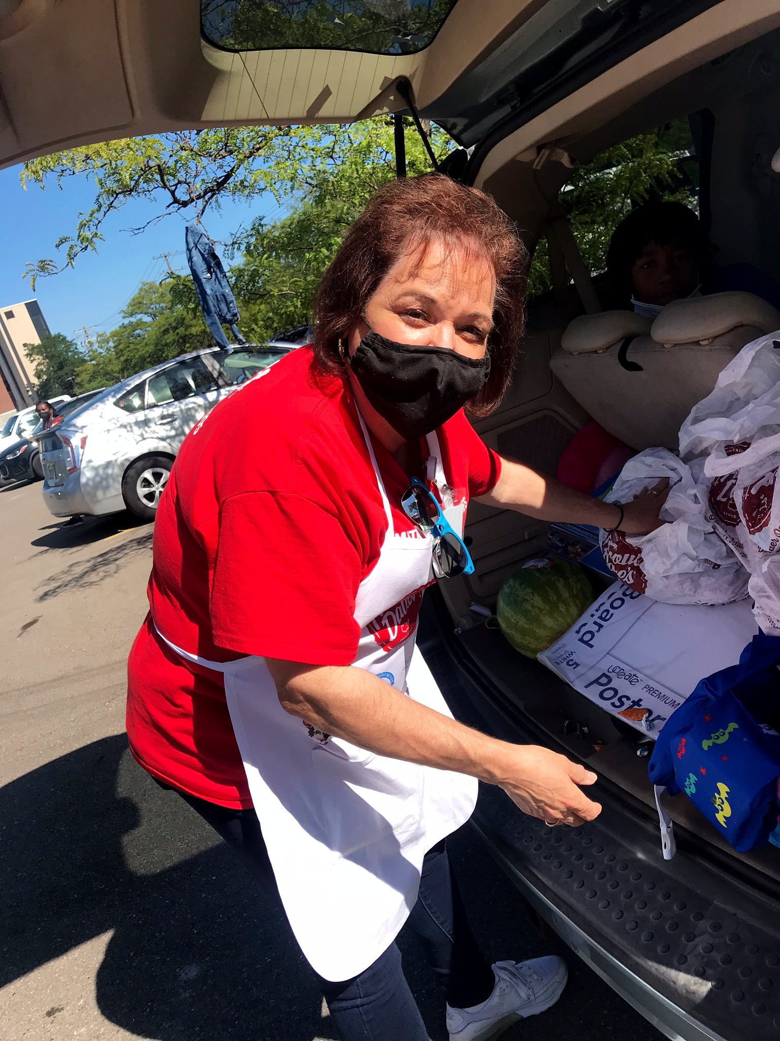one woman volunteer for Higher Hopes putting food in trunk of car